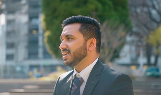 Suraj, a man with short dark hair and beard, speaks to someone off-camera.