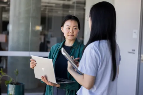 Two women engaged in a conversation about cyber security.