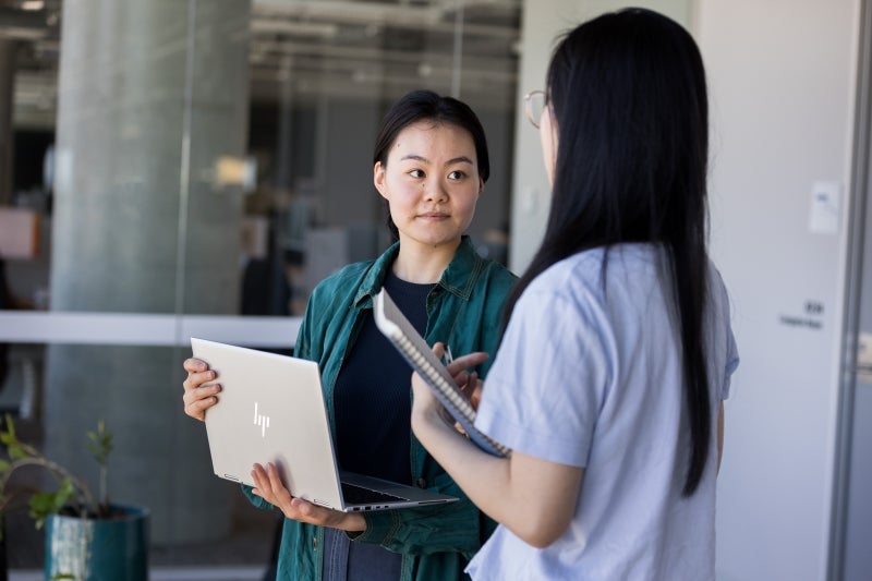 Two women engaged in a conversation about cyber security.